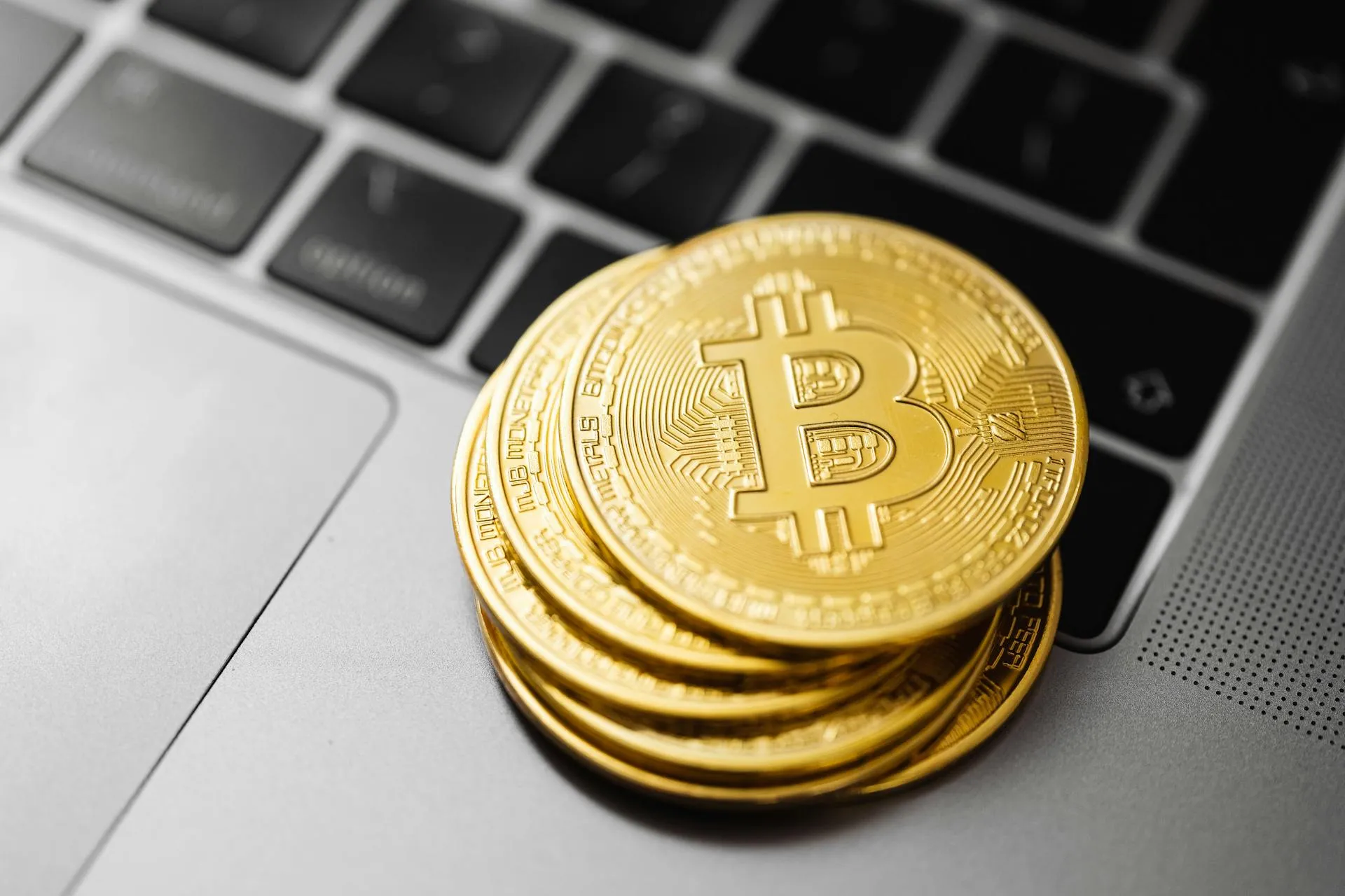 A stack of physical Bitcoins on the laptop