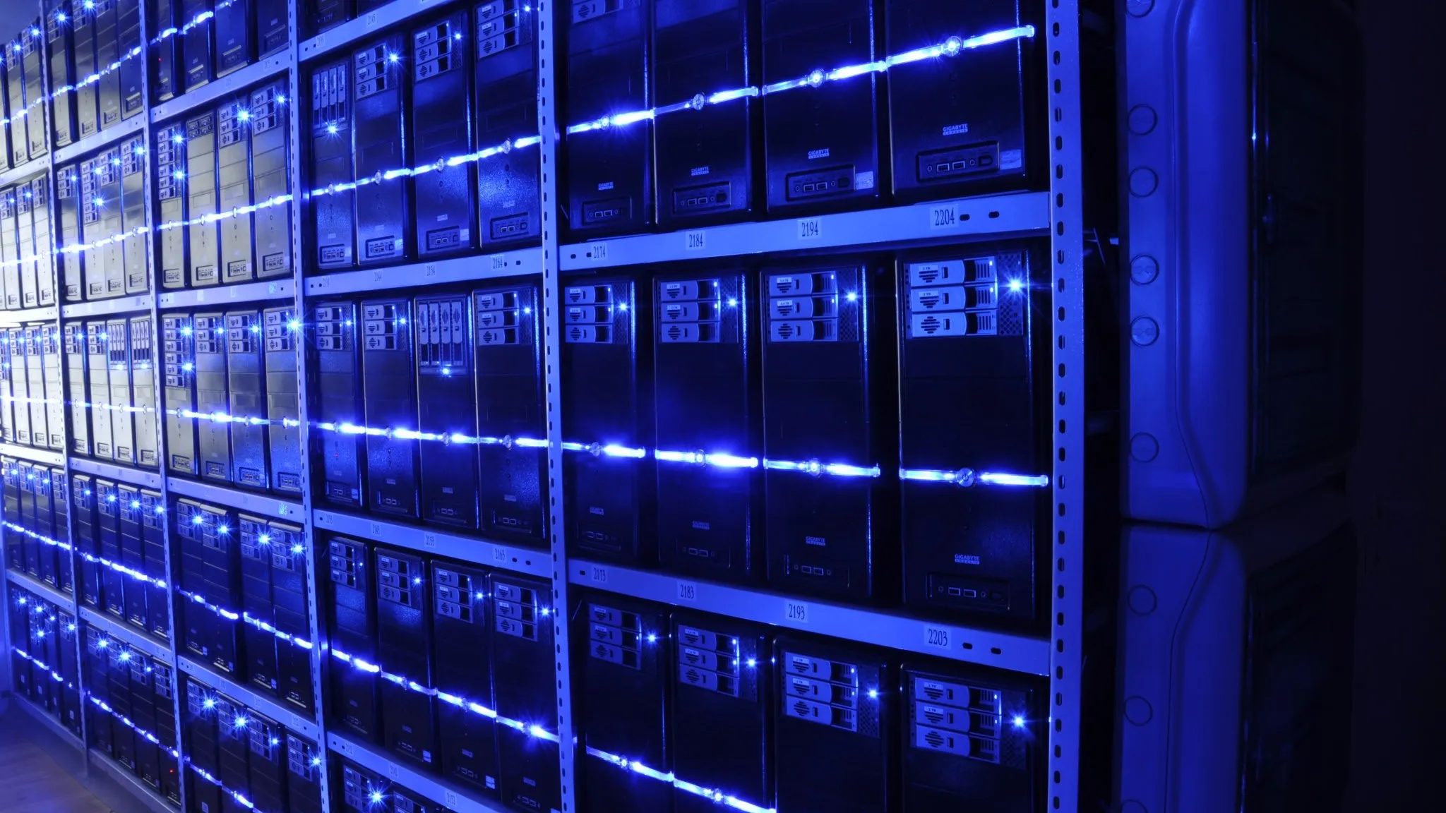Rows of servers in a data centre, lit blue, stacked from floor to ceiling