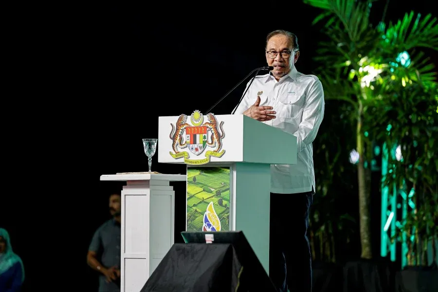 Prime Minister of Malaysia standing on stage to give a speech