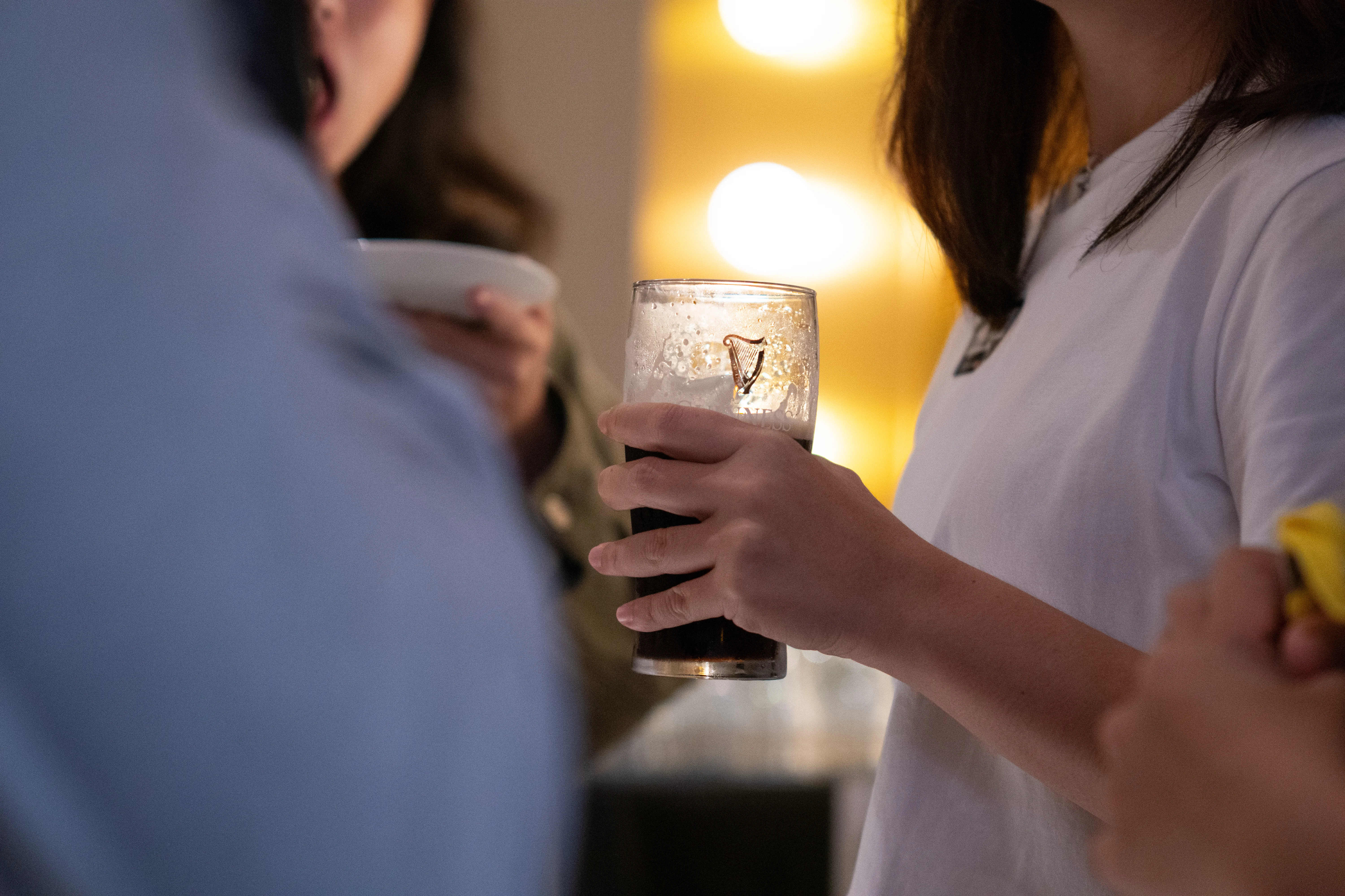 A woman holds a Guinness stout beer